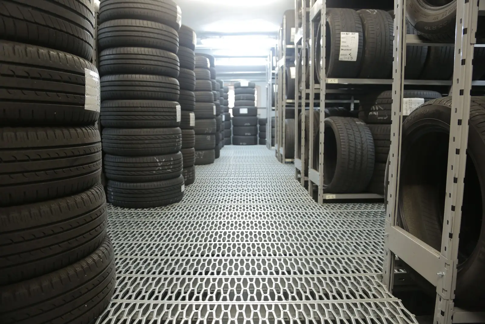 Rows of tires stacked on shelves in a tire storage aisle